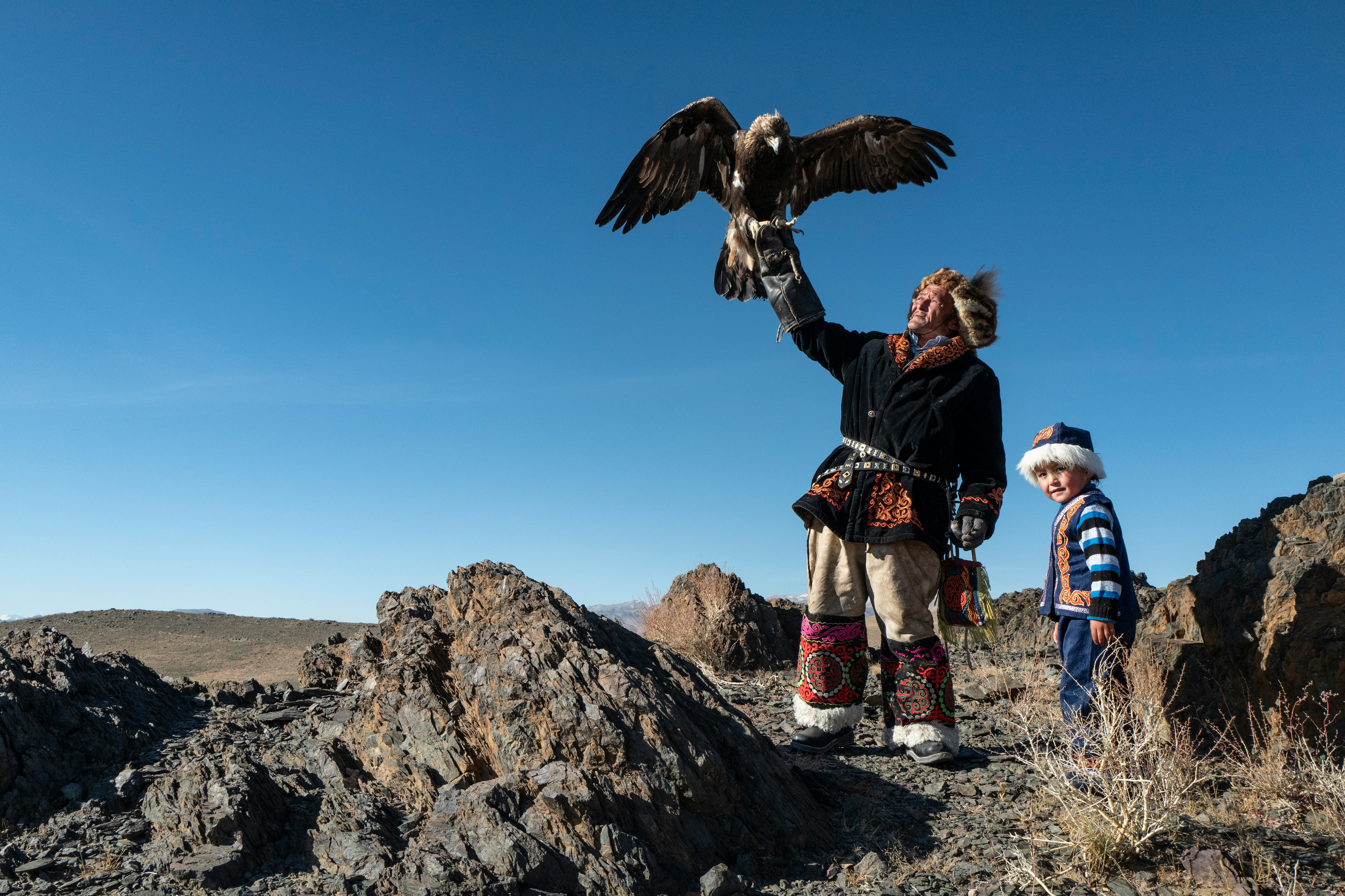 Kazakh eagle hunter and child in western Mongolia
